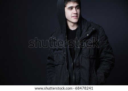 Young attractive happy man wearing black jacket with hood.
