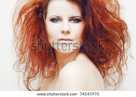 Beautiful young fashion model with curly red hair.