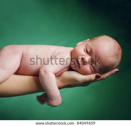 Beautiful new born baby resting on mom\'s hand.