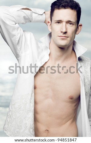 Young handsome fashion model posing in white shirt.