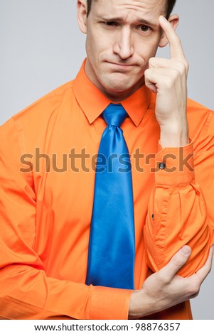 Young handsome happy man in orange shirt and blue tie.