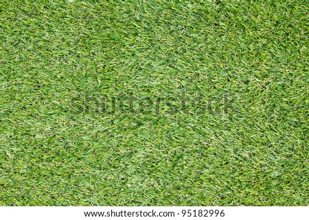 Background texture with fake grass in a public children playground, top view