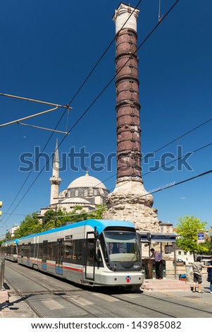 ISTANBUL - MAY 26: A modern tram stopped at the column of Constantine (Burnt Column) on may 26, 2013 in Istanbul, Turkey. Istanbul is a modern city with a developed infrastructure.