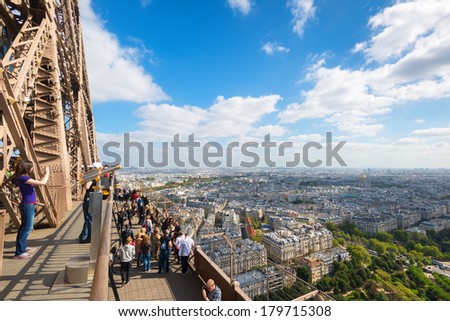 PARIS - SEPTEMBER 20, 2013: Tourists are on the observation deck of the Eiffel Tower in Paris. The Eiffel tower is one of the major tourist attractions of France.