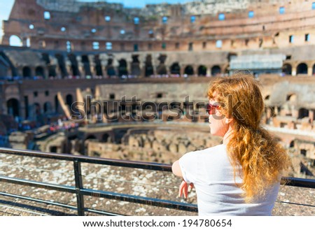 ROME - MAY 1O: Young female tourist looks at the Colosseum on may 10, 2014 in Rome, Italy. The Colosseum is an important monument of antiquity and is one of the main tourist attractions of Rome.