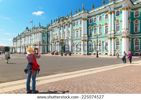 ST PETERSBURG, RUSSIA - JUNE 14, 2014: Female tourist take pictures of the Winter Palace in Saint Petersburg, Russia