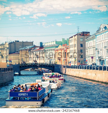 ST PETERSBURG, RUSSIA - JUNE 13, 2014: Tourist boats floating on the Moyka River. St. Petersburg was the capital of Russia and attracts many tourists.
