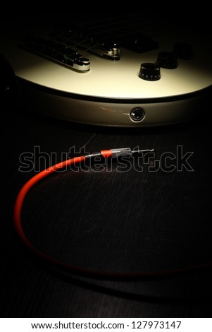 Detail on an electrical guitar and a red cord