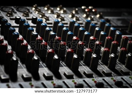 Detail of a music mixer desk with various knobs
