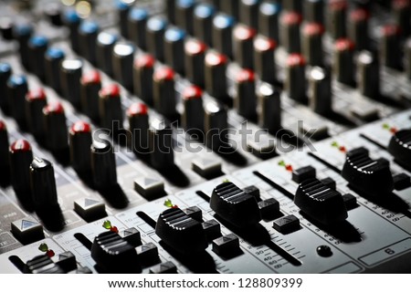 Detail of a music mixer desk with various knobs