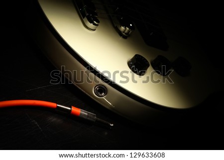 Detail on an electrical guitar and a red cord