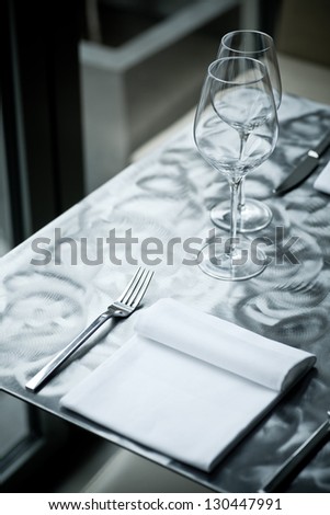 Fine restaurant dinner table place setting with napkin and wineglass