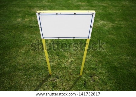 Horizontal shot of a blank white billboard on a field