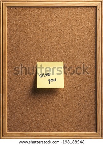 Color shot of a cork board with a sticky note reading \