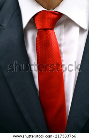 Business man wearing a suit with a red tie. Detail on the tie.