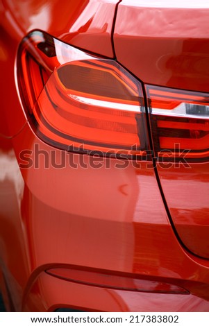 Detail on the rear light of a red car.