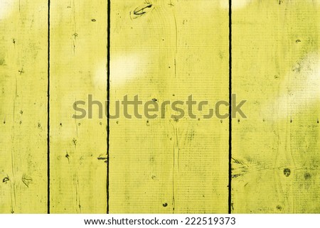 Color shot of an yellow wooden fence.