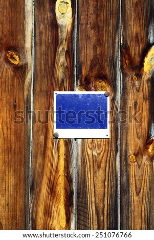 Color picture of some wood planks with a blue sign on them.