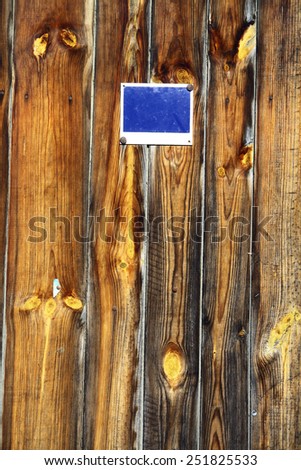 Color picture of some wood planks with a blue sign on them.