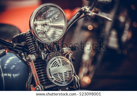 Close up shot of a vintage motorcycle headlight and horn.