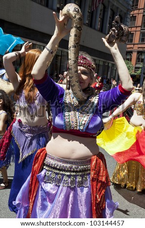 NEW YORK - MAY 19: Member of Andrea Belly dance group performs with python snake on Broadway as part of New York Dance Parade on May 19, 2012 in New York City