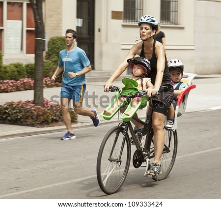 NEW YORK - AUGUST 04: Unidentified mom with 2 kids rides bicycle along Park Avenue during Summer Streets sponsored by Department of Transportation in Manhattan on August 4, 2012 in New York
