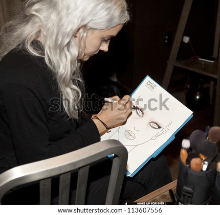 NEW YORK - SEPTEMBER 11: Makeup artist makes drawing backstage for Lars Andersson Collection during Spring/Summer 2013 at Mercedes-Benz Fashion Week in Grand Soho Yard on September 11 2012 in New York