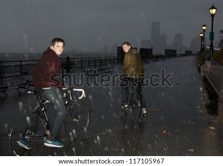 NEW YORK - OCTOBER 29: Brave New Yorker bike despite bad weather on embankment in Battery Park while water is surging as result of hurricane Sandy on October 29, 2012 in New York City