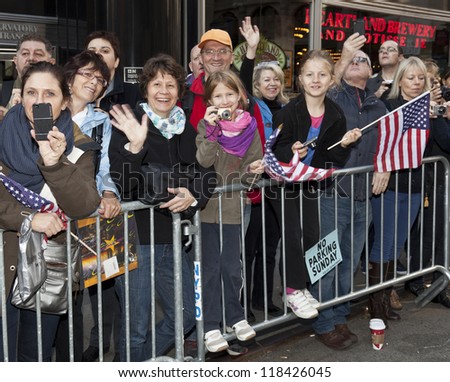 NEW YORK - NOVEMBER 11: People wave to veterans and active duty military at Veteran\'s Day Parade along 5th Avenue on November 11, 2012 in New York City