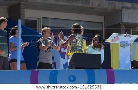 NEW YORK - AUGUST 24: First Lady Michelle Obama greets young players on stage during Arthur Ashe Kids Day presentation at Billie Jean King National Tennis Center on August 24, 2013 in New York City