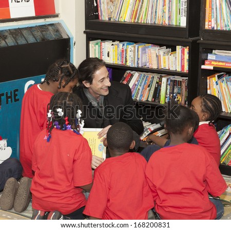 NEW YORK - DECEMBER 20: Adrien Brody reads book during Post-Sandy Holiday Party at The Action Center presented by Bulgari & Save the Children on Dec 20, 2013 in Far Rockaway of Queens in NYC