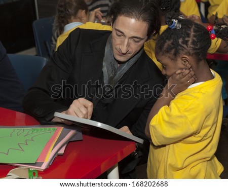 NEW YORK - DECEMBER 20: Adrien Brody draws with kids during Post-Sandy Holiday Party at The Action Center presented by Bulgari & Save the Children on Dec 20, 2013 in Far Rockaway of Queens in NYC