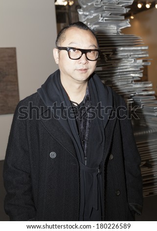 NEW YORK, NY - MARCH 5 2014: Artist Yuan Gong poses in front of his sculpture Turning Back at contemporary art exhibition presented by Tianrenheyi Art Center at The Armory Show Focus: China at Pier 94