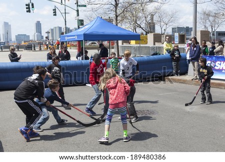 NEW YORK, NY - APRIL 26, 2014: Kids play hockey sponsored by ESPN and New York Rangers at Family festival during the 2014 Tribeca Film festival on Greenwich street