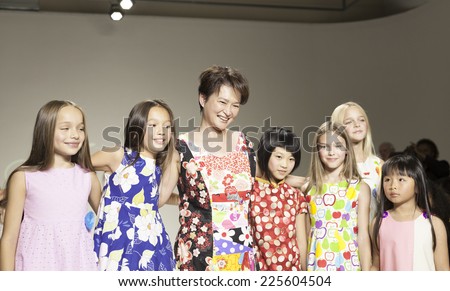 New York, NY - October 19, 2014: Designer Peini Yang and kids walk runway for PetiteParade Kids Fashion week at Bath House Studios