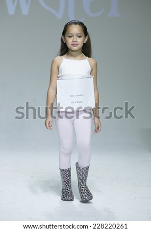 New York, NY - October 18, 2014: Girl walks runway during rehearsal for Oil & Water design at PetiteParade Kids Fashion week at Bath House Studios