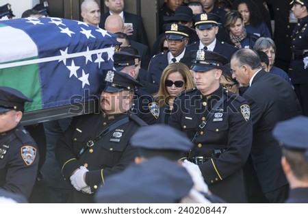 NEW YORK, NY - DECEMBER 27, 2014: Casket of murdered New York Police Officer Rafael Ramos is carried out of Christ Tabernacle church in Queens as Maritza Ramos watches