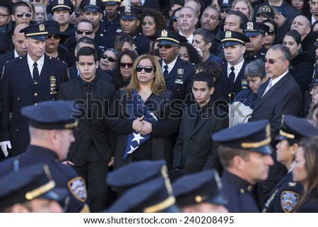 NEW YORK, NY - DECEMBER 27, 2014: Maritza Ramos, Justin Ramos and Jared Ramos hold colors at  Christ Tabernacle Church for the funeral of slain New York City Police Officer Rafael Ramos