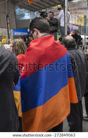 New York, NY - April 26, 2015: Man wrapped into Armenian flag at rally in Manhattan Times Square to mark centennial of the deaths of 1.5 million Armenians under the Ottoman Empire in 1915