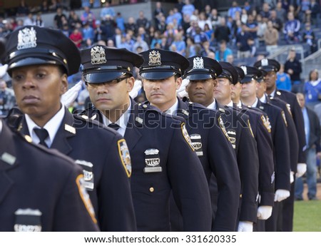 New York, NY - October 25, 2015: NYC police officers salute before match between NYC FC & New England Revolution at Yankee Stadium