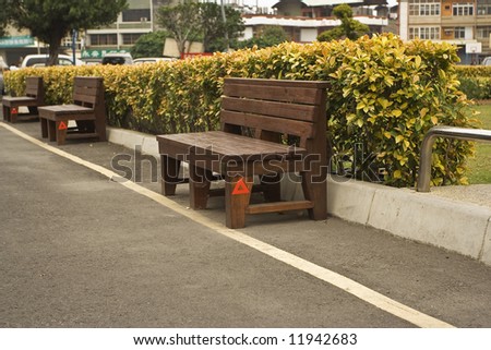 bench row with red triangle warning sign in Taiwanese town square
