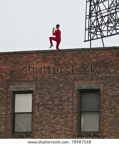NEW YORK - JUNE 10: Dancer of Trisha Brown Dance Company performs Roof Piece on rooftops of buildings along Highline Park on June 10, 2011 in New York City