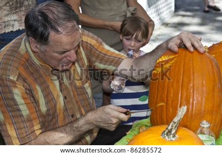 NEW YORK - OCTOBER 09: Hugh McMahon demonstrates the art of pumpkin carvings to visitors in preparation for Halloween in Central park on October 09, 2011 in New York City