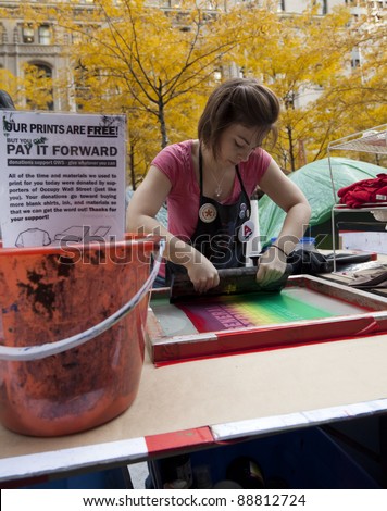 NEW YORK - NOVEMBER 14: Unidentified protester with \'Occupy Wall Street\' makes prints on t-shirts in exchange for donations on November 14, 2011 in New York.