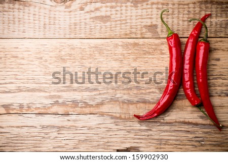 Chili pepper on the wooden background.