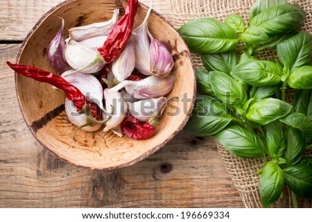 Bunch fresh basil on a wooden background. Garlic mixture in a bowl.