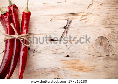 Red chili peppers on a wooden background. The menu background.