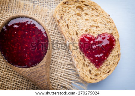 Grain slice of bread with jam heart shape.