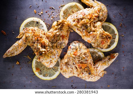Chicken wings marinated on the grey background.