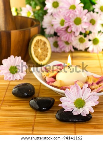 Spa treatment.Burning candle,  spa stones, dry lemon, pink flowers.
